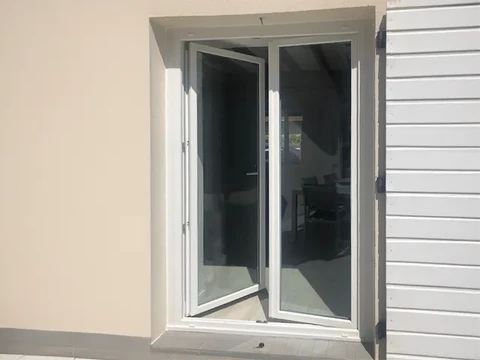 Façade extérieure d'habitation avec porte-fenêtre à deux vantaux ouverte donnant sur l'intérieur