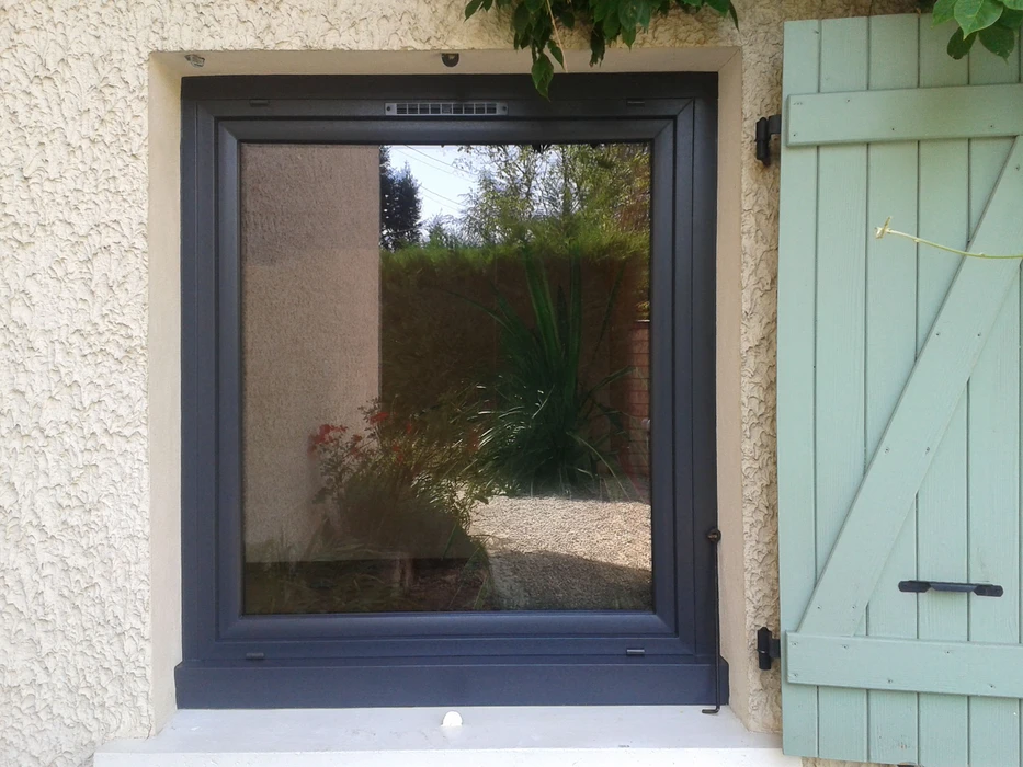 Façade extérieure d'habitation avec porte-fenêtre à deux vantaux ouverte donnant sur l'intérieur