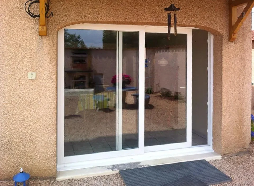 Façade extérieure d'habitation avec porte-fenêtre à deux vantaux ouverte donnant sur l'intérieur