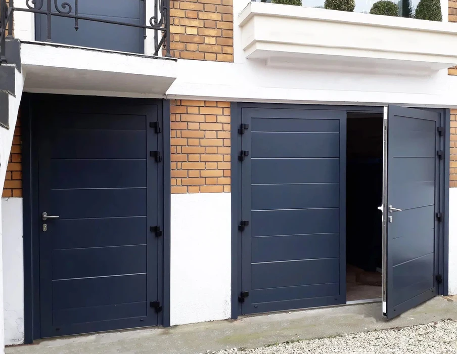 Extérieur d'une habitation avec grande baie vitrée coulissante à cadre blanc PVC installée dans mur crépi beige