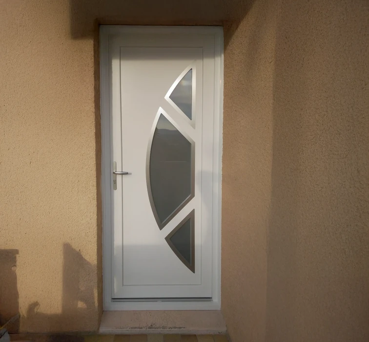 Extérieur d'une habitation avec grande baie vitrée coulissante à cadre blanc PVC installée dans mur crépi beige