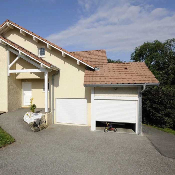 Extérieur résidentiel avec porte de garage sectionnelle blanche à trois panneaux