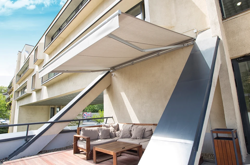 Femme détendue sur terrasse de restaurant, robe rayée rouge et blanche, verre à la main, souriant dans ambiance ensoleillée